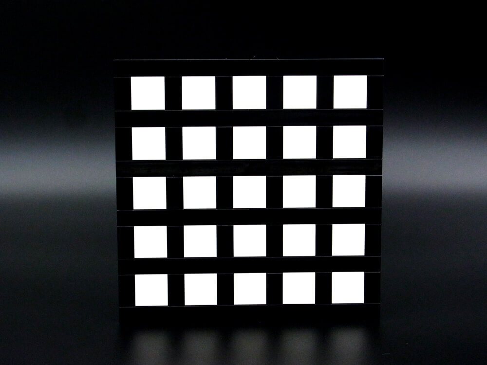 ヘルマン格子錯視のレゴ作品。白い四角タイルに張り巡らされた黒いタイルの交差点が明るく見えます。