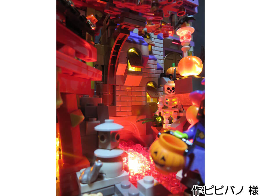 ハロウィンと日本の秋が融合した作品。二つの建物の間には赤く光る川が流れています。