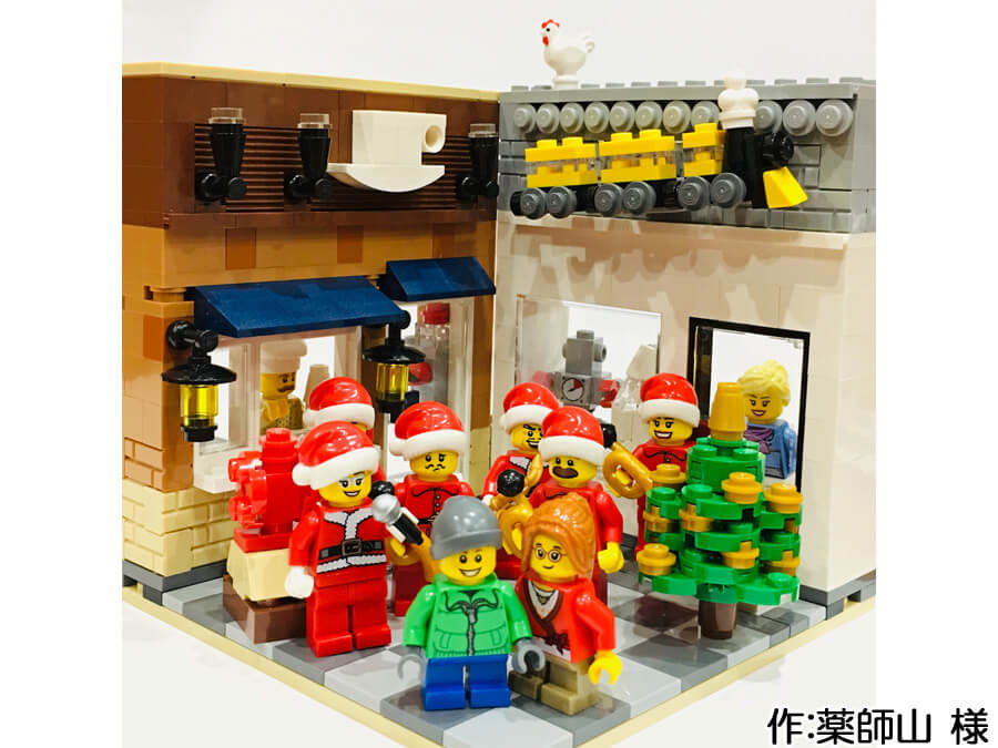 サンタに扮した音楽隊が街角の広場に集まるクリスマス作品。後ろにはカフェとおもちゃ屋があります。